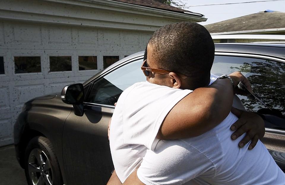 Donna Harrison gets a hug from her son, Tremaine Leonard, who just got home from Indianapolis, Saturday, June 1, after tornadoes destroyed part of the neighborhood last Monday. Volunteer groups and residents worked together Saturday to clear debris from some of the neighborhoods in Trotwood and other areas hit by the tornado. WHIO File