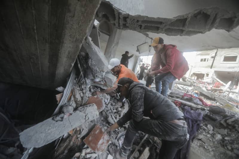 Palestinians search for victims under the rubble of destroyed buildings after heavy Israeli bombardment of the Al-Maghazi camp in the central Gaza Strip. The Hamas-controlled Ministry of Health said more than 70 people were killed. Mohammed Talatene/dpa