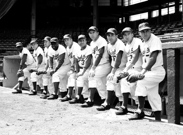 Roy Campanella, catcher for the Brooklyn Dodgers, sitting next to Jackie  Robinson in the dugout during a baseball game] / Eide.