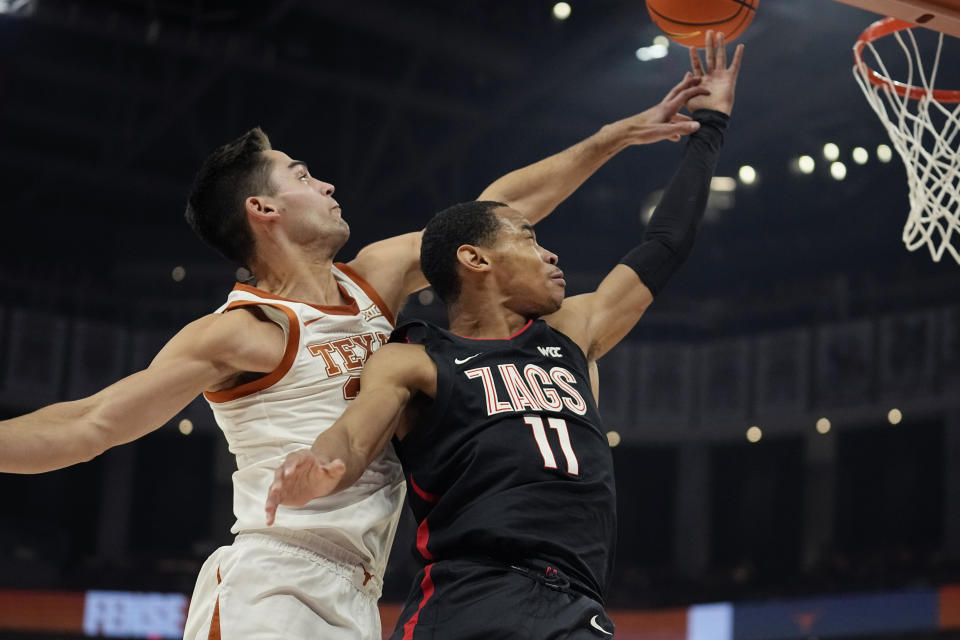 Gonzaga guard Nolan Hickman (11) drives to the basket against Texas forward Brock Cunningham (30) during the first half of an NCAA college basketball game, Wednesday, Nov. 16, 2022, in Austin, Texas. (AP Photo/Eric Gay)