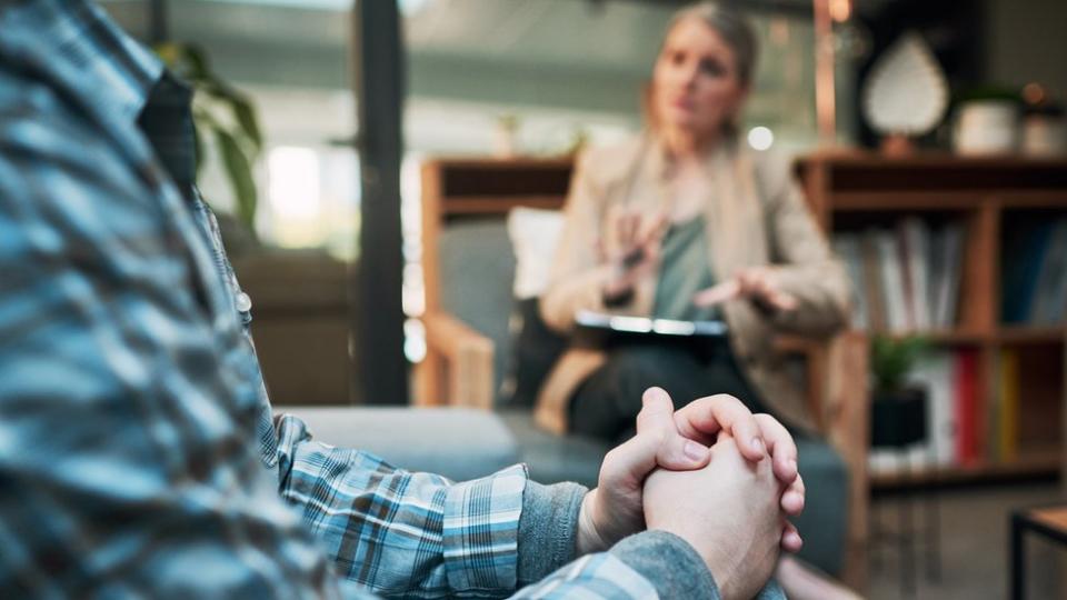 Una terapeuta escucha a un paciente en una sesión