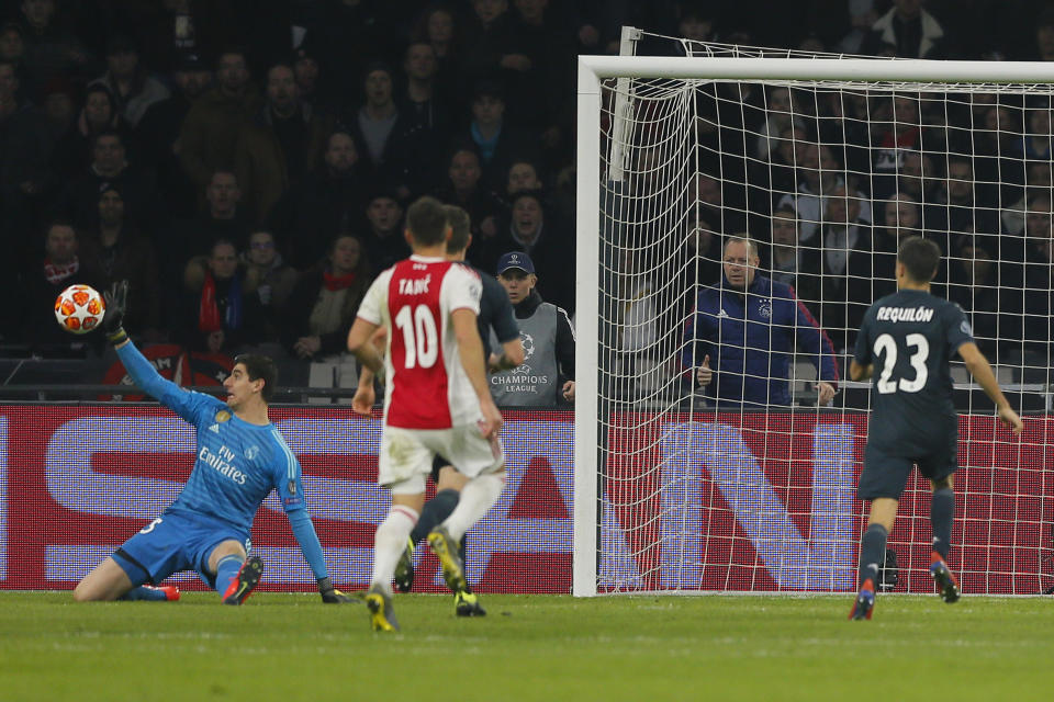 Real goalkeeper Thibaut Courtois, left, makes a save during the first leg, round of sixteen, Champions League soccer match between Ajax and Real Madrid at the Johan Cruyff ArenA in Amsterdam, Netherlands, Wednesday Feb. 13, 2019. (AP Photo/Peter Dejong)