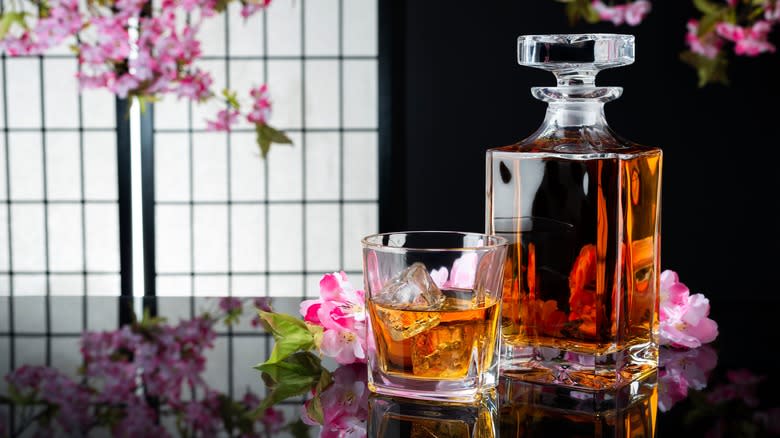 Whisky decanter with glass and cherry blossoms
