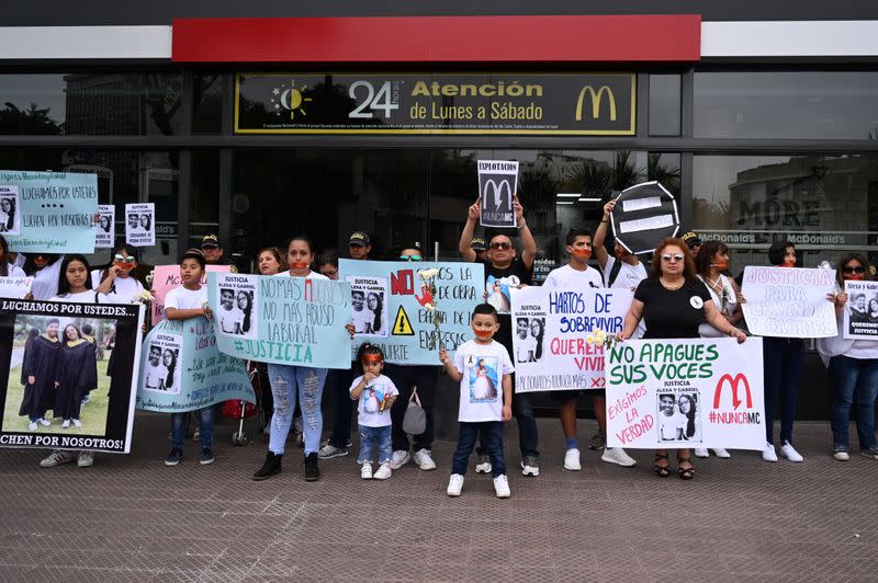 People protest outside a closed McDonald's restaurant, after the the deaths of two teenaged employees, in Lima