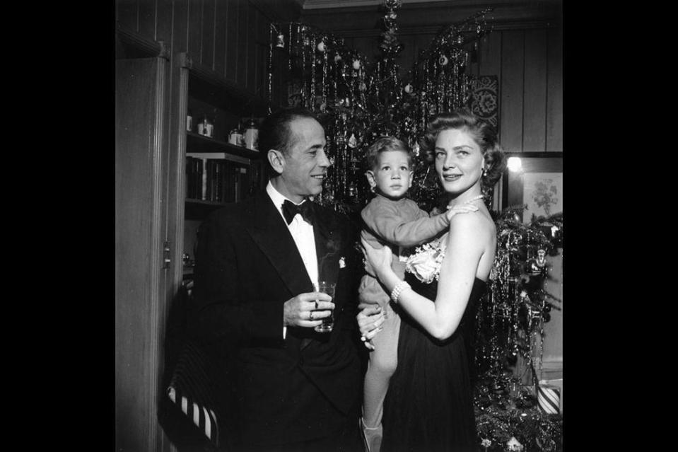 <p>Lauren Bacall and Humphrey Bogart pose with their young son, Stephen, on Christmas Eve in 1951. The Hollywood couple dressed to impress for the black-tie soirée—Bogart donned a tuxedo, while Bacall wore a black strapless gown and pearls.</p>