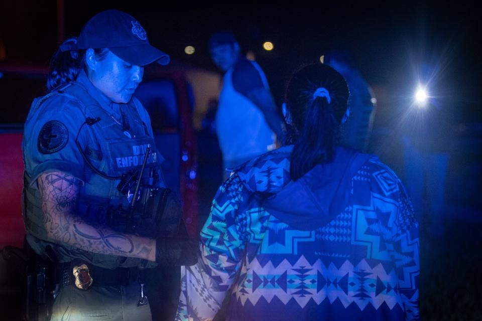 MHA Drug Enforcement patrol agent Britney Larvie, left, questions a resident during a traffic stop in Parshall, N.D.