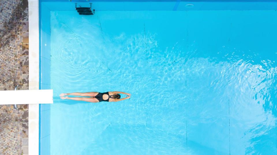 Aerial view of woman diving into swimming pool