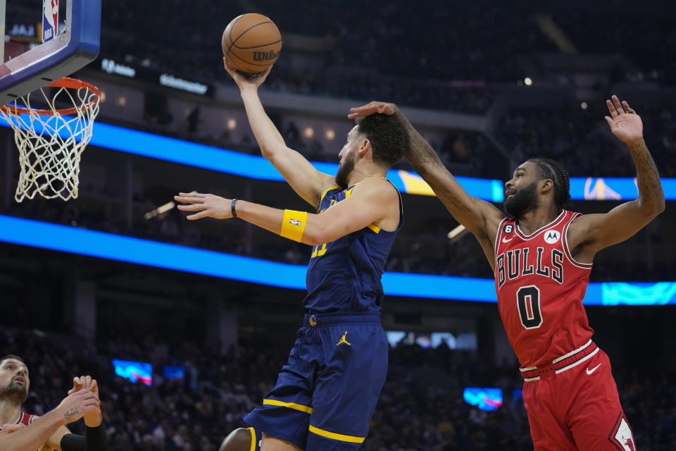 Chicago Bulls guard Coby White (0) fouls Golden State Warriors guard Klay Thompson (11), who scored during the first half of an NBA basketball game in San Francisco, Friday, Dec. 2, 2022. (AP Photo/Godofredo A. Vásquez)