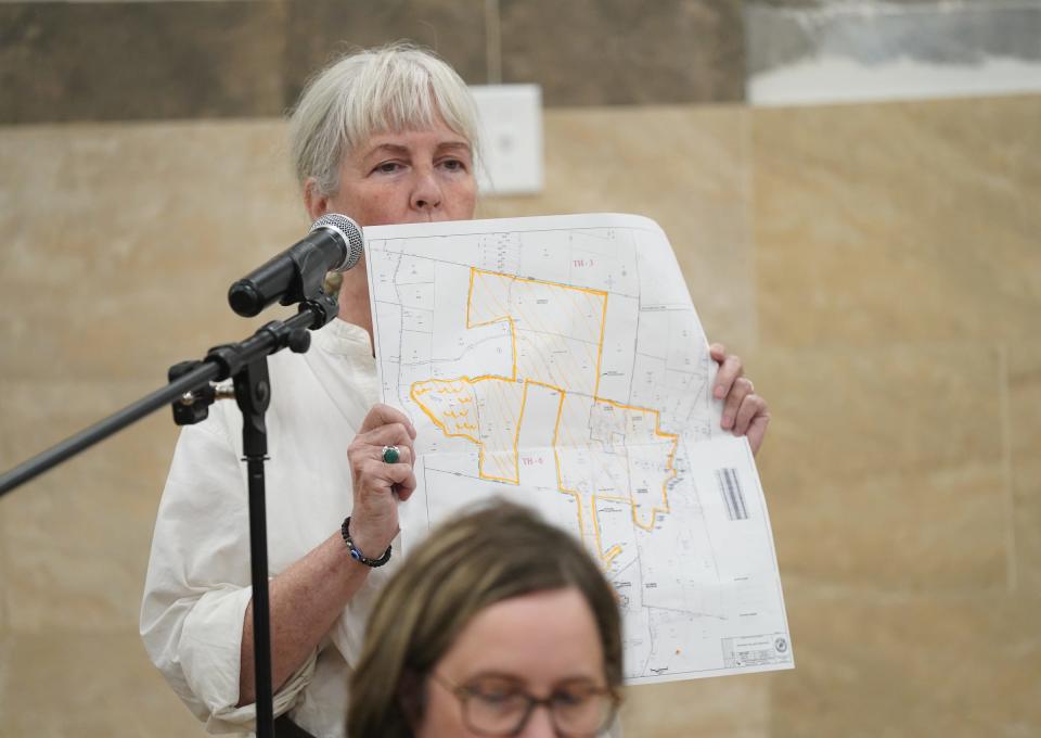 Ann Finnereran of Hurleyville holds up a map during a public hearing on a petition to create a village within the borders of the towns of Thompson and Fallsburg at Viznitz Institutions synagogue in Kiamesha Lake on Thursday, August 3, 2023.