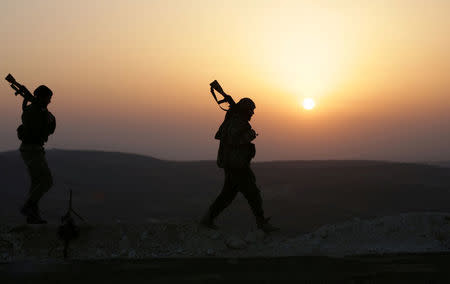 Turkish-backed Free Syrian Army fighters walk as the sun sets in Eastern Afrin countryside, Syria, February 6, 2018. REUTERS/Khalil Ashawi