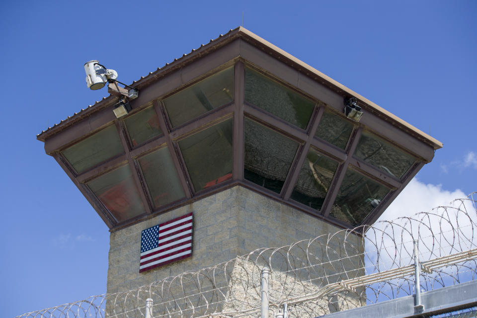 FILE - In this June 17, 2019, file photo reviewed by U.S. military officials, an American flag is displayed on the control tower of the Camp VI detention facility in Guantanamo Bay Naval Base, Cuba. The White House says it intends to shutter the prison on the U.S. base in Cuba, which opened in January 2002 and where most of the 39 men still held have never been charged with a crime. (AP Photo/Alex Brandon, File)