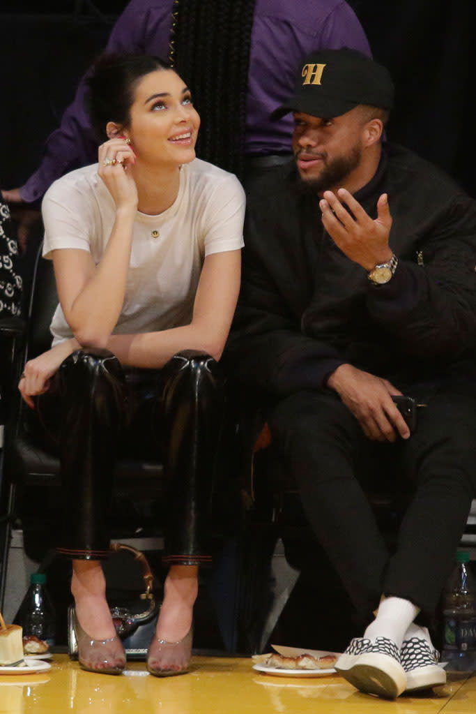 Kendall Jenner wears clear Yeezy mules while sitting courtside at the Jan. 29 L.A. Lakers game. - Credit: Splash News