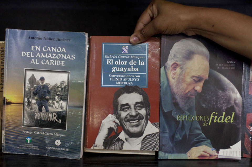 A woman shows a book by Colombian author Gabriel Garcia Marquez for sale next to a book by Fidel Castro at a state-run bookstore in Havana, Cuba, Thursday, April 17, 2014. Garcia Marquez, who died at his home in Mexico City on Thursday, became a hero to the Latin American left as an early ally of Cuba's revolutionary leader Fidel Castro. (AP Photo/Franklin Reyes)