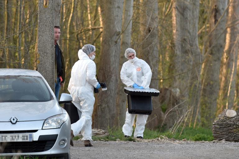 French forensics experts work at the site in the Dubrulle forest where the dead body of a nine-year-old girl was found near the port city of Calais, on April 15, 2015