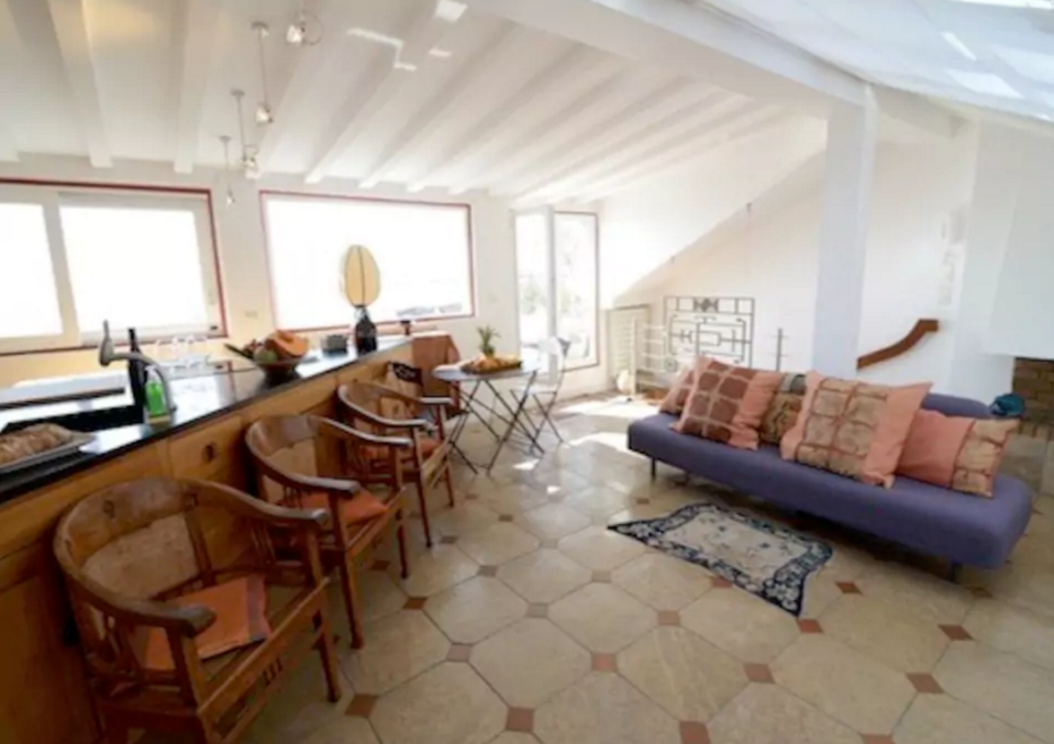 <p>The residence is eclectically decorated with both eastern and western themes, and, of course, plenty of art. The living room has plenty of light thanks to its skylight. (Airbnb) </p>