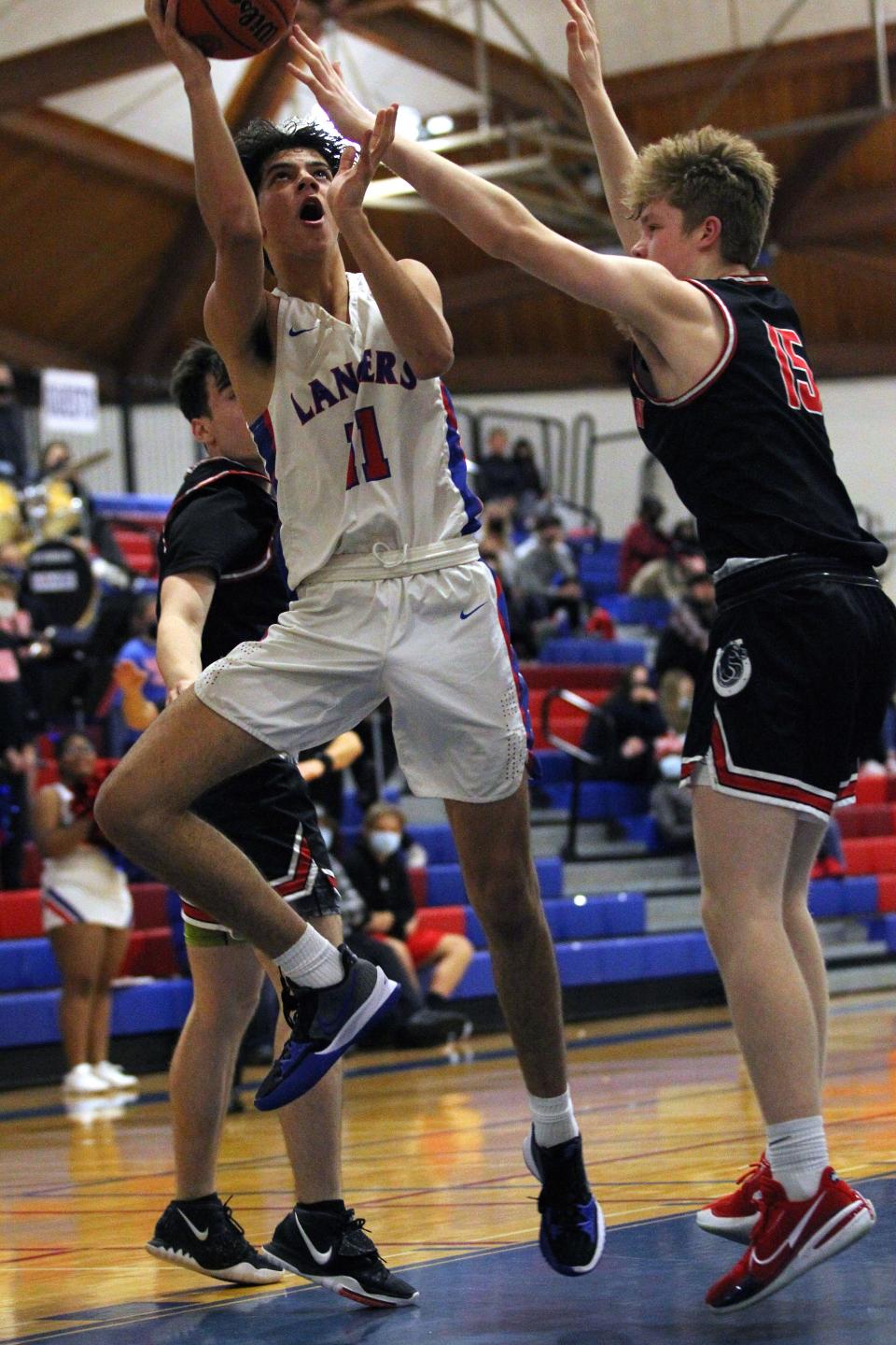 Churchill’s Cooper Case gets off a shot over Thurston’s Nate Stiffler during Friday’s Midwestern League basketball game.
