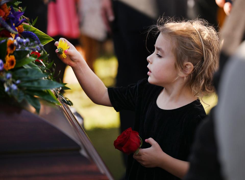 Ella Dastrup, a great granddaughter, places a small flower on the casket of President M. Russell Ballard after the graveside service in the Salt Lake City Cemetery on Friday, Nov. 17, 2023. | Scott G Winterton, Deseret News