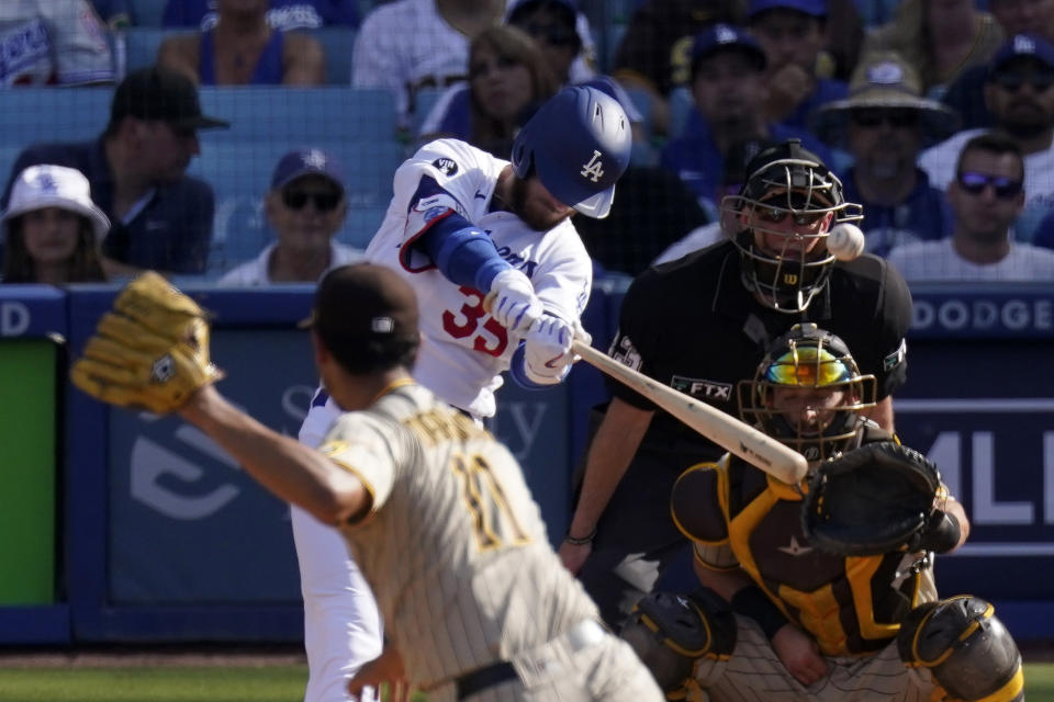 Los Angeles Dodgers' Cody Bellinger, second from left, hits a solo home run as San Diego Padres starting pitcher Yu Darvish, left, watches along with catcher Austin Nola, right, and home plate umpire Lance Barksdale during the third inning of a baseball game Sunday, Aug. 7, 2022, in Los Angeles. (AP Photo/Mark J. Terrill)