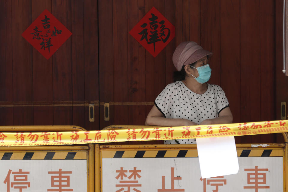 FILE - In this May 18, 2021, file photo, a woman wearing face mask to protect against the spread of the coronavirus lines up at a rapid coronavirus testing center after the infection alert rose to level 3 in Taipei, Taiwan. After a year of success, Taiwan is struggling with its largest outbreak since the pandemic began. When locally transmitted cases started being found in May 2021, it soon became clear that the central government was ill prepared not only to contain them, but to even detect them on a large scale due to a lack of investment in and a bias against rapid testing. (AP Photo/Chiang Ying-ying, File)