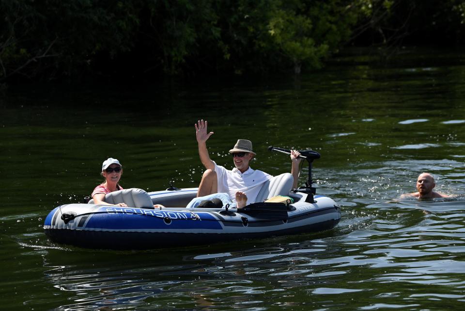 People swim and relax in a dinghy on the River Thames at Shepperton (Toby Melville/Reuters)
