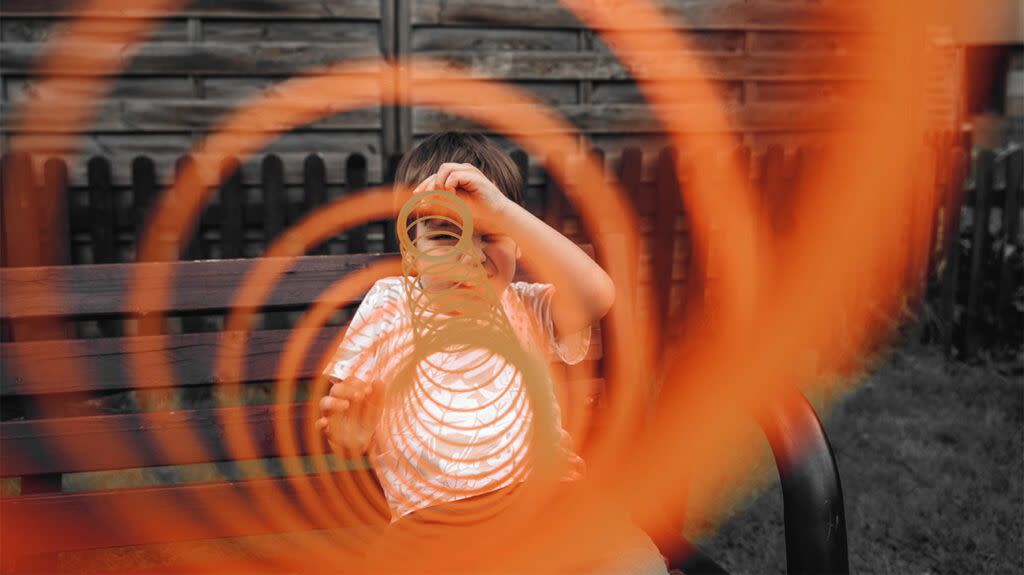 Young male pulls a slinky toy