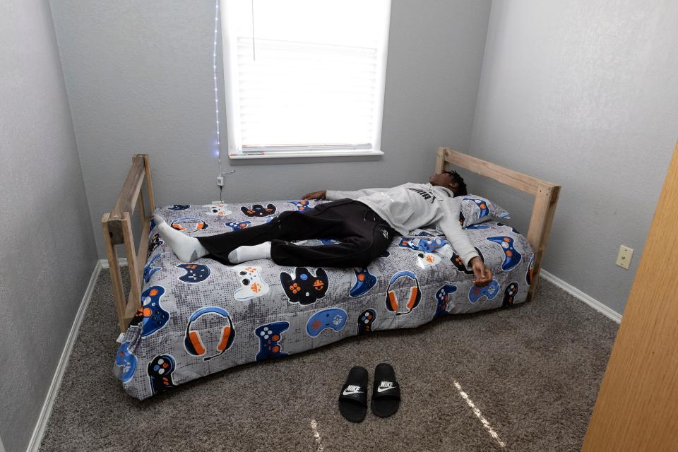 A'Kerrion, 16, falls asleep on his new bed that was assembled and delivered by volunteers with the Sleep in Heavenly Peace-Oklahoma City chapter.