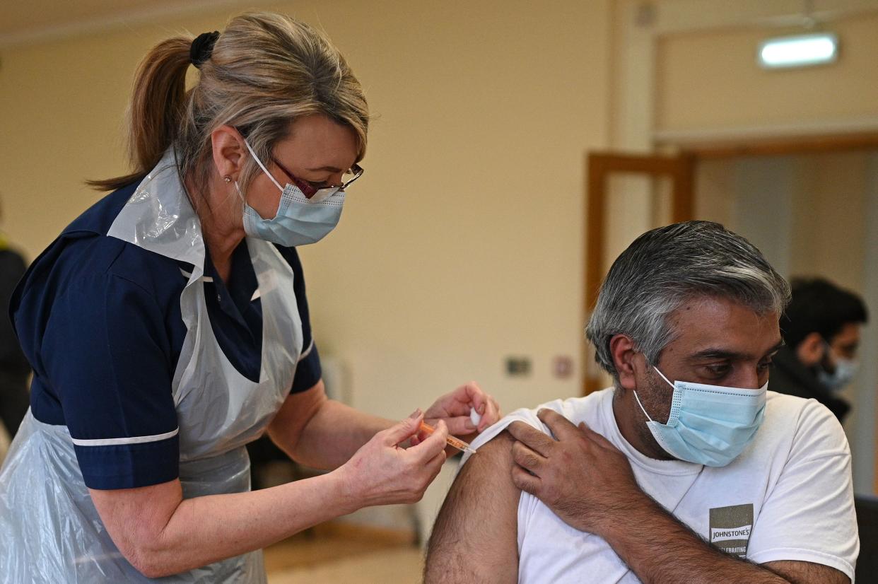 Nurse Maggie Clark administers a dose of the AstraZeneca/Oxford Covid-19 vaccine to a patient at a vaccination centre set up at the Fiveways Islamic Centre and Mosque in Nottingham, central England, on February 22, 2021. - Coronavirus vaccines do not contain pork or make you infertile: a celebrity advertising pitch is striving to counter a worrying lag among certain ethnic minorities affecting Britain's otherwise impressive inoculation campaign. (Photo by Oli SCARFF / AFP) (Photo by OLI SCARFF/AFP via Getty Images)