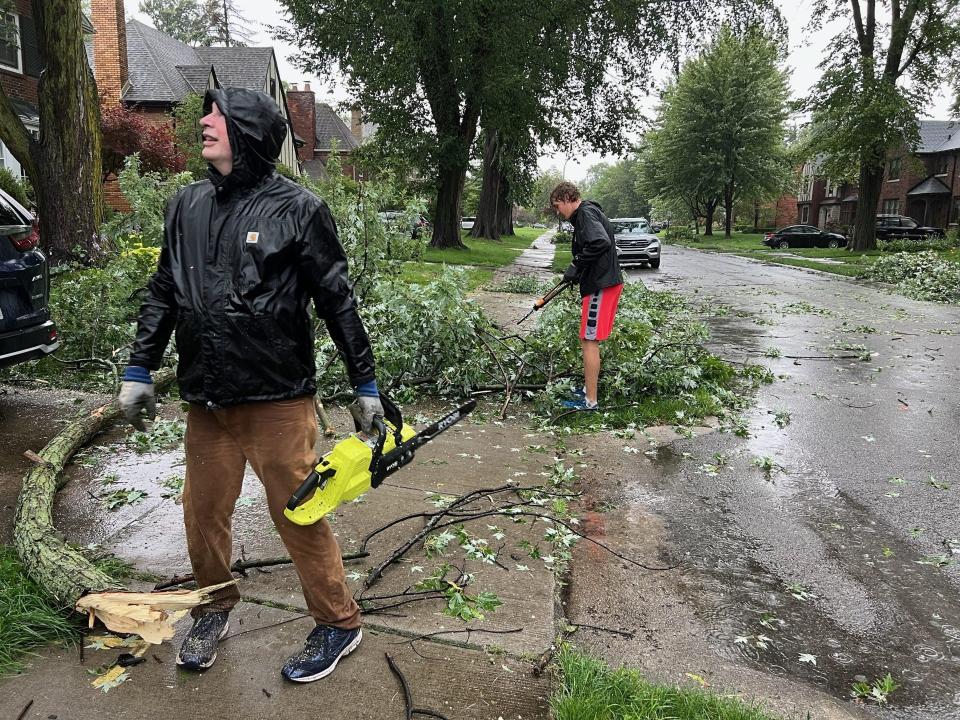Bill Shuster and Logan Detweiler of Grosse Pointe Park clear limbs from their neighborÕs driveway on Bedford Road after heavy storms rolled through the area on Wednesday afternoon, July 26, 2023.