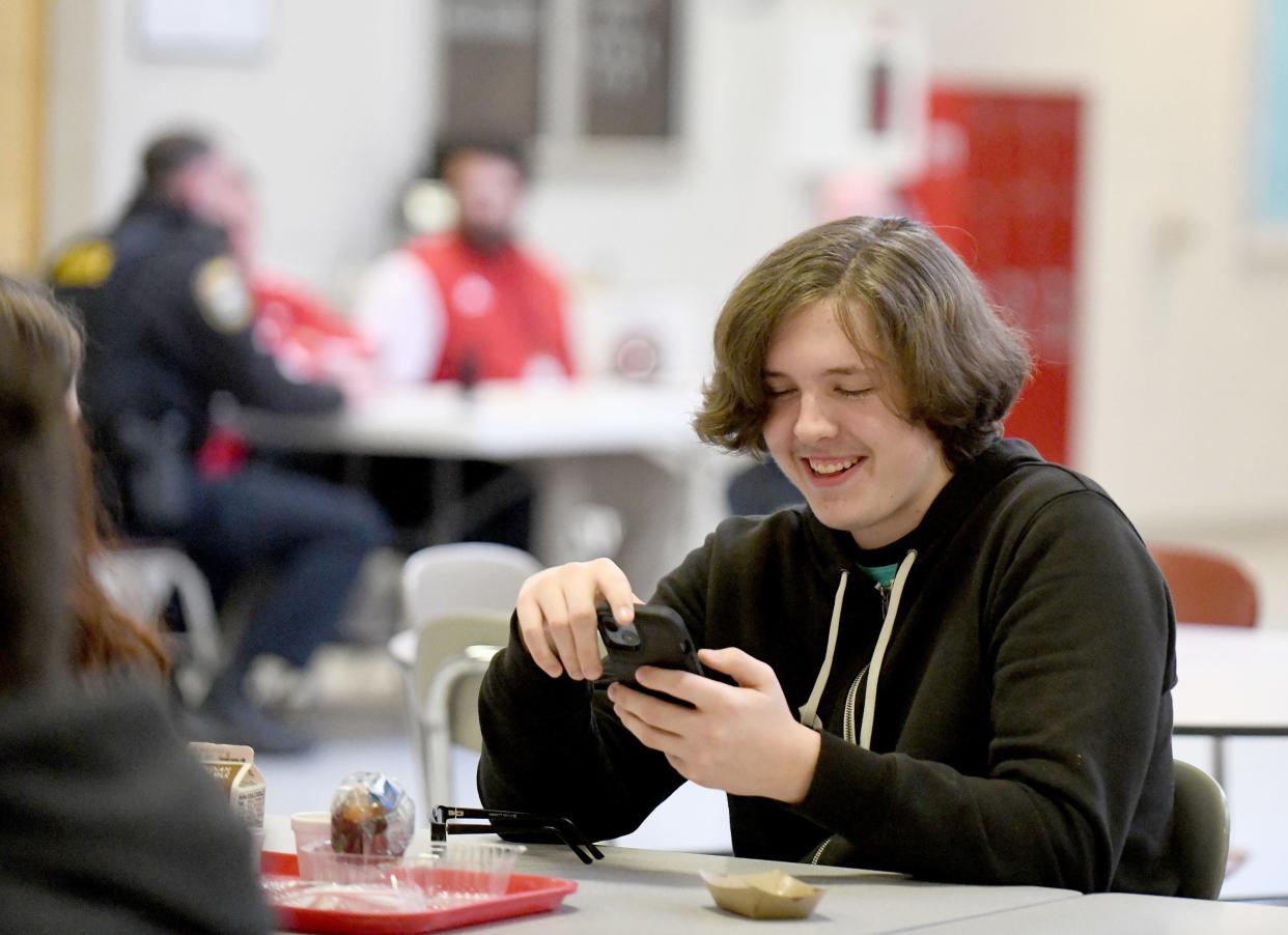 Northwest High School sophomore Brandon Frase, 15, catches up on his cellphone during lunch break at the school. Students are permitted to use their phones at lunch, in the hallways between classes and in study halls. They must place their phones in a pouch during classes.