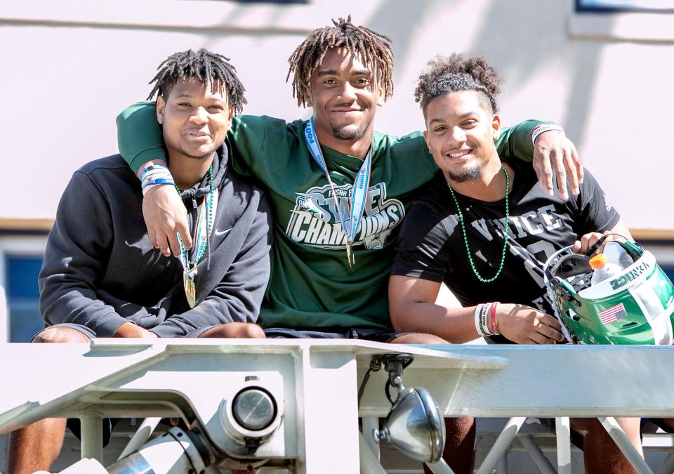 Venice High School football players, from left, Tyler Louis, Damon Wilson and Dominic Wood celebrate their Class 8A state championship with a parade in the team’s honor in downtown Venice.