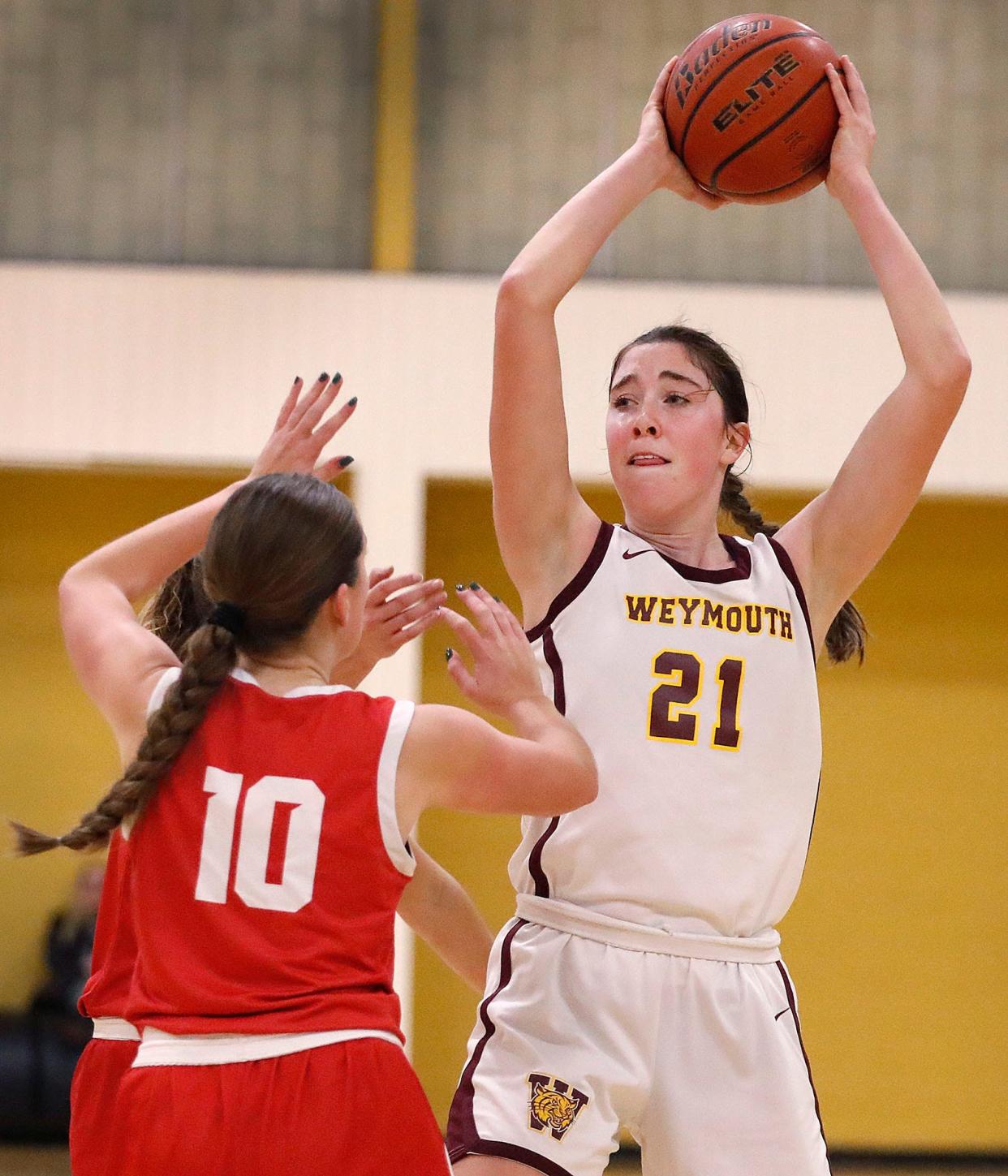 Weymouth forward Megan Doyle looks for an open teammate near the hoop while being covered by Milton's Grace Pater in a girls basketball game on Friday, Jan. 5, 2024.