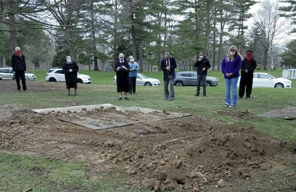 In this April 24, 2020, photo provided by Sister Mary Alfonsa Van Overberghe, nuns from a convent in Livonia, and others gather at the burial site of one of 13 nuns who have died from the coronavirus in the Michigan city. (Sister Mary Alfonsa Van Overberghe via AP)
