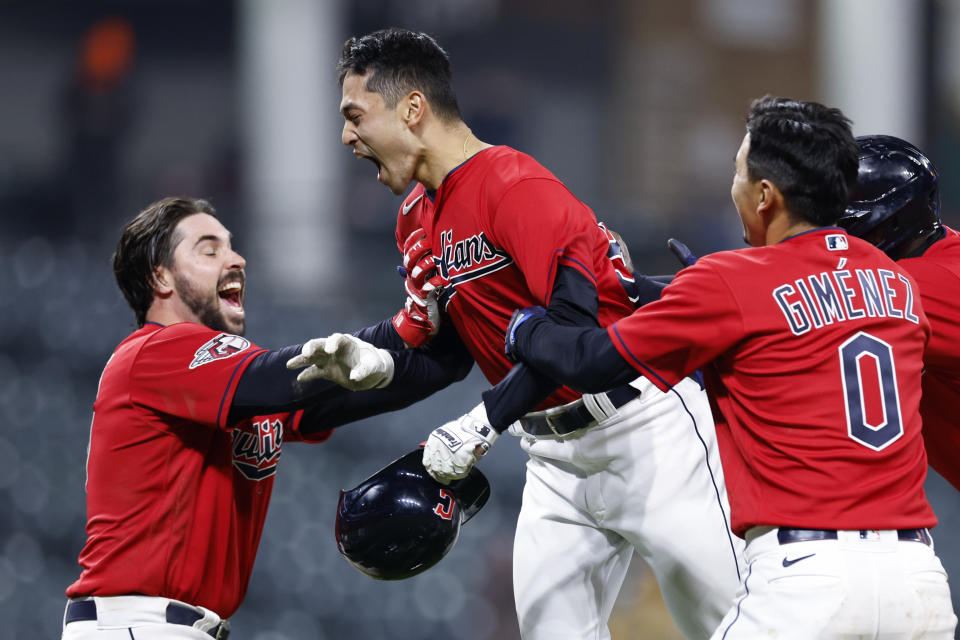 Cleveland Guardians' Steven Kwan, center, celebrates with Austin Hedges, left, and Andrés Giménez after driving in the winning run against the San Diego Padres in the 10th inning of the second baseball game of a doubleheader, Wednesday, May 4, 2022, in Cleveland. (AP Photo/Ron Schwane)