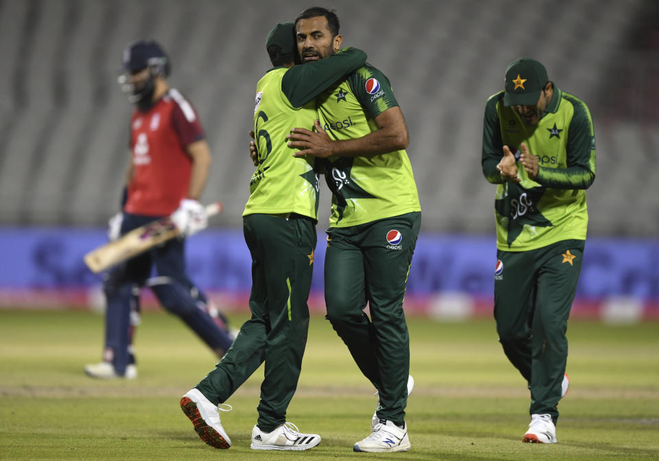 Pakistan's Wahab Riaz, second right, celebrates with captain Babar Azam, second left, the dismissal of England's Moeen Ali, far left, during the third Twenty20 cricket match between England and Pakistan, at Old Trafford in Manchester, England, Tuesday, Sept. 1, 2020. (Mike Hewitt/Pool via AP)