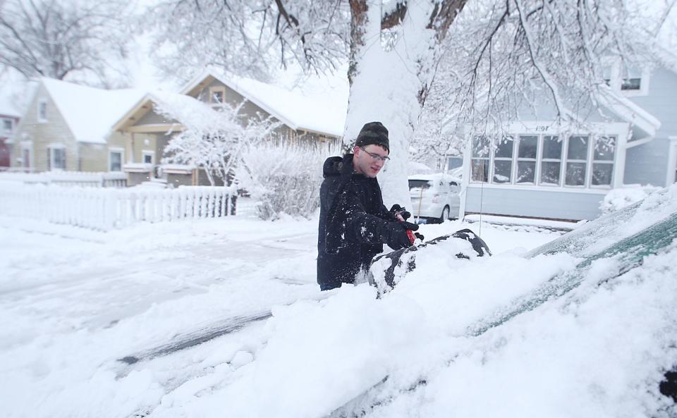 John Cplley removes snow from his car after receiving almost 9 inches of snow in a winter storm on Tuesday, Jan. 9, 2024, in Ames, Iowa.