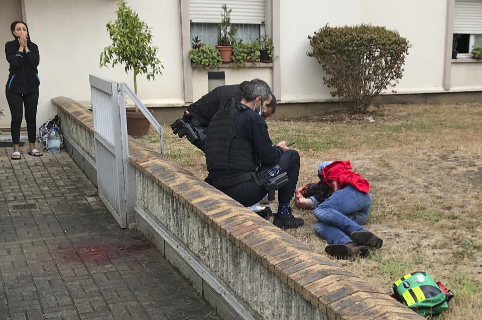 Un hombre que se encuentra en el suelo es auxiliado después de que fuera herido durante un ataque con arma blanca en París, el viernes 25 de septiembre de 2020. (David Cohen vía AP)