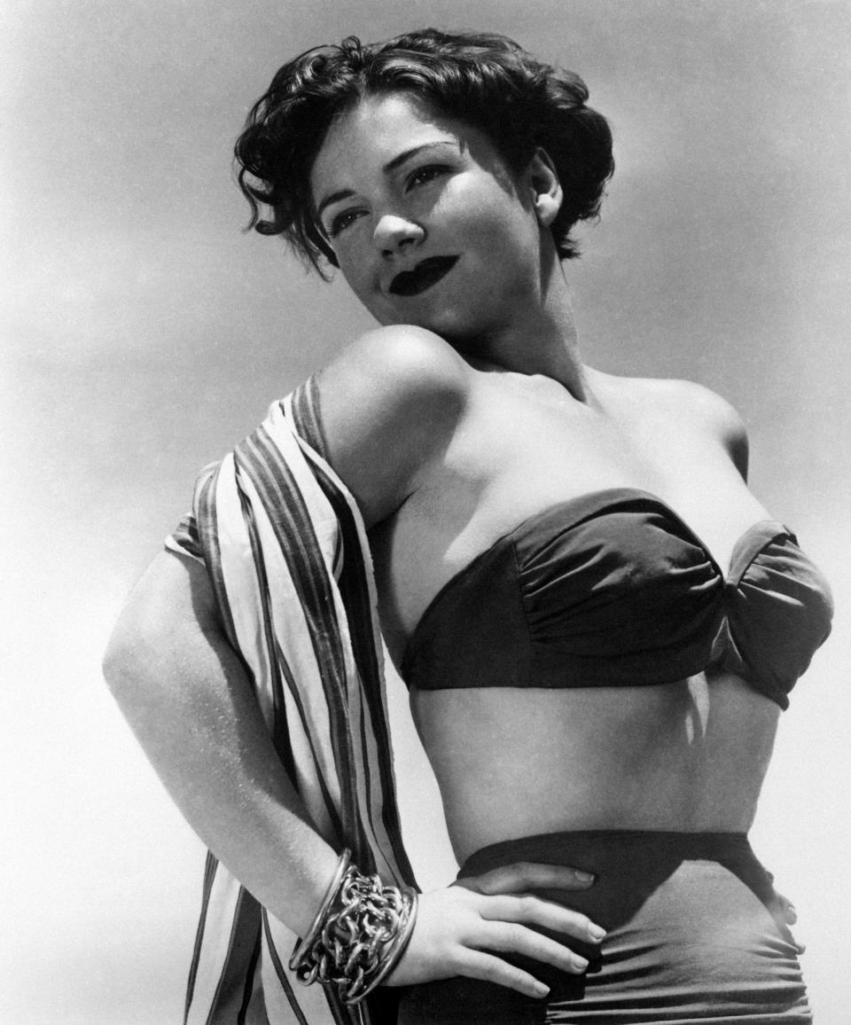 Wearing a strapless bikini top and matching bottoms, circa 1950s.