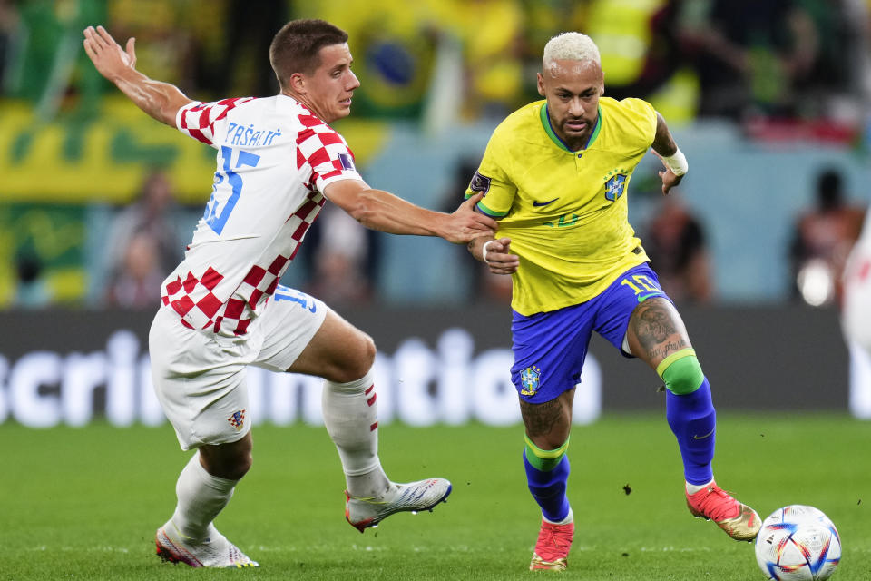 El volante croata Mario Pasalic sujeta al atacante brasileño Neymar en el partido por los cuartos de final del Mundial, el viernes 9 de diciembre de 2022, en Rayán, Qatar. (AP Foto/Manu Fernández)