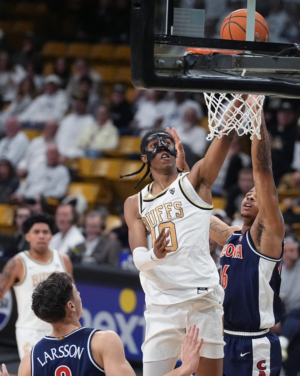 Colorado forward Cody Williams, center, drives to the basket between Arizona guard Pelle Larsson, left, and forward Keshad Johnson during the second half of an NCAA college basketball game Saturday, Feb. 10, 2024, in Boulder, Colo. (AP Photo/David Zalubowski)