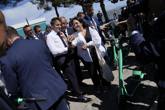 French President Emmanuel Macron and his Portuguese counterpart Marcelo Rebelo de Sousa, center, pose for a photo with a well-wisher outside the venue hosting the United Nations Ocean Conference in Lisbon, Thursday, June 30, 2022. From June 27 to July 1, the United Nations is holding its Oceans Conference in Lisbon expecting to bring fresh momentum for efforts to find an international agreement on protecting the world's oceans. (AP Photo/Armando Franca)