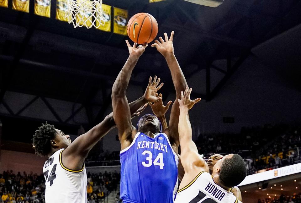 Dec 28, 2022; Columbia, Missouri, USA; Kentucky Wildcats forward Oscar Tshiebwe (34) goes up for a shot against Missouri Tigers guard Kobe Brown (24) and guard Nick Honor (10) and forward Aidan Shaw (23) during the first half at Mizzou Arena. Mandatory Credit: Jay Biggerstaff-USA TODAY Sports