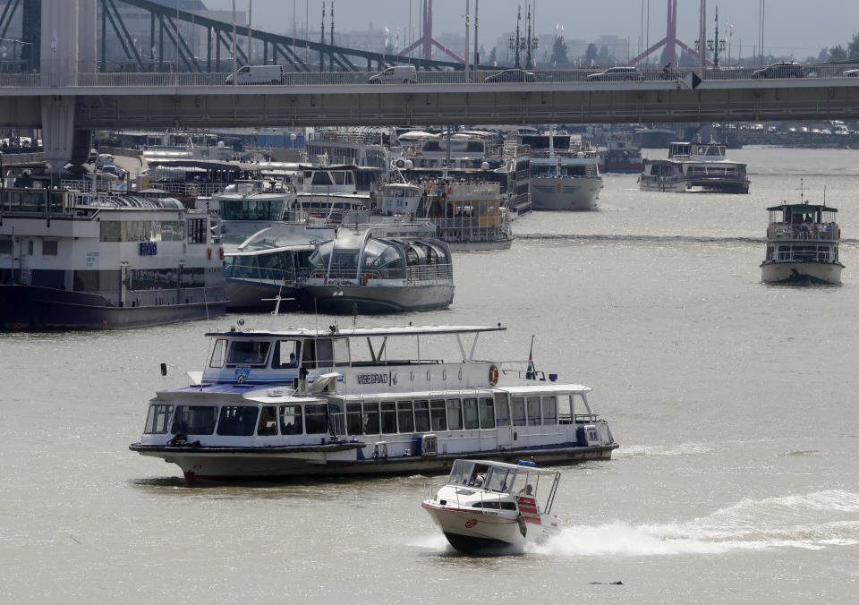 In this photo taken on Wednesday, June 5, 2019, sightseeing, restaurant and tour boats are seen on the Danube River near the Elizabeth Bridge in Budapest. A tourism boom in the Hungarian capital has led to major congestion on the river flowing through the city, with sightseeing boats and floating hotels competing for better positions in front of spectacular neo-Gothic buildings, ornate bridges and churches lining the Danube. (AP Photo/Laszlo Balogh)