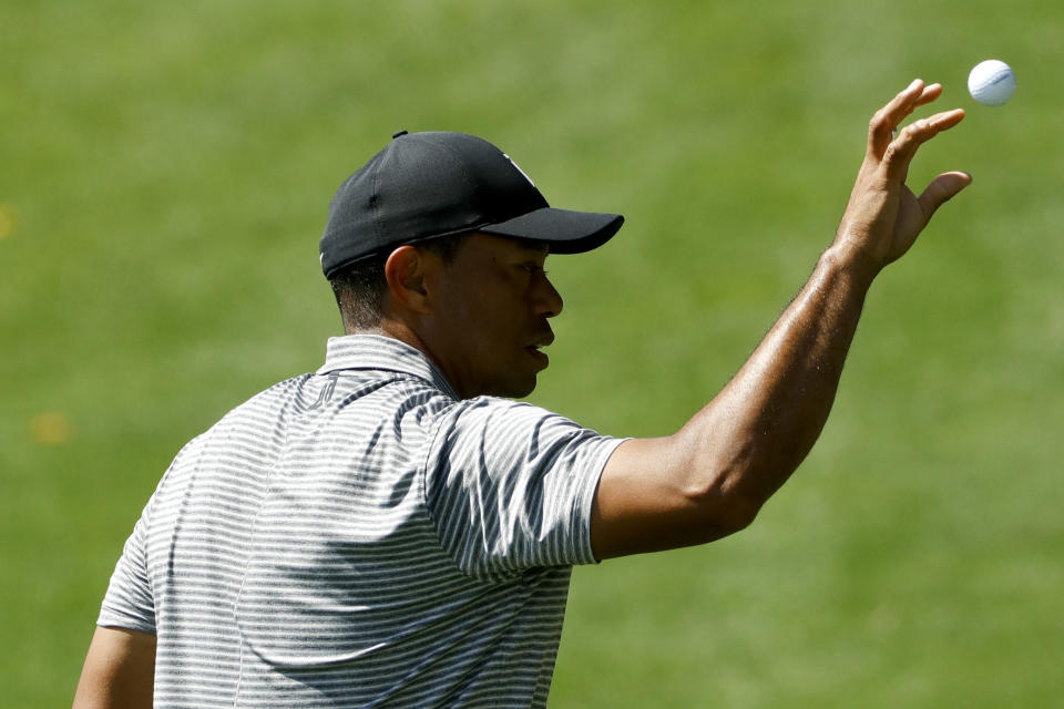 Tiger Woods gets a ball from his caddie on the driving range at the Masters golf tournament Tuesday, April 9, 2019, in Augusta, Ga. (AP Photo/Matt Slocum)