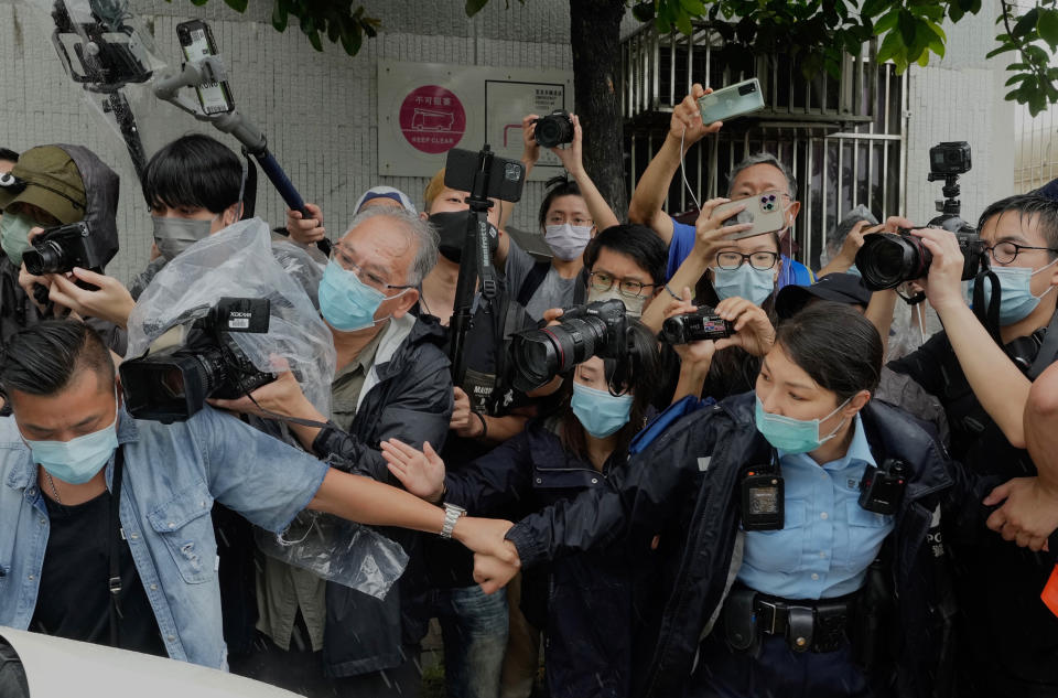 Photographers surround a van which was carrying Agnes Chow, a prominent pro-democracy activist sentenced to jail last year for taking part in unauthorized assemblies during the 2019 protest movement, after her release Saturday, June 12, 2021, in Hong Kong. (AP Photo/Vincent Yu)