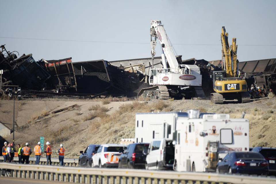 Workers toil to clear cars that derailed in an accident over Interstate 25 northbound, Monday, Oct. 16, 2023, north of Pueblo, Colo. (AP Photo/David Zalubowski)