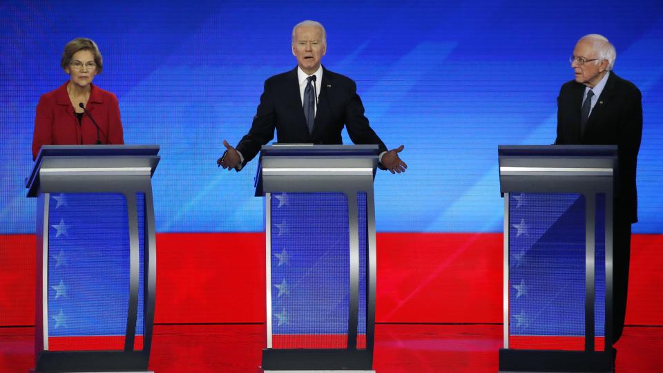 FILE - In this Feb. 7, 2020, file photo Democratic presidential candidate former Vice President Joe Biden, center, speaks as Sen. Elizabeth Warren, D-Mass., left, and Sen. Bernie Sanders, I-Vt., listen during a Democratic presidential primary debate hosted by ABC News, Apple News, and WMUR-TV at Saint Anselm College in Manchester, N.H. Sanders and Warren, the faces of the Democratic Party's far-left wing, are at risk of being excluded from the senior ranks of President-elect Biden's administration as the incoming president balances the demands of his party's progressive base against the political realities of a narrowly divided Senate. (AP Photo/Elise Amendola, File)