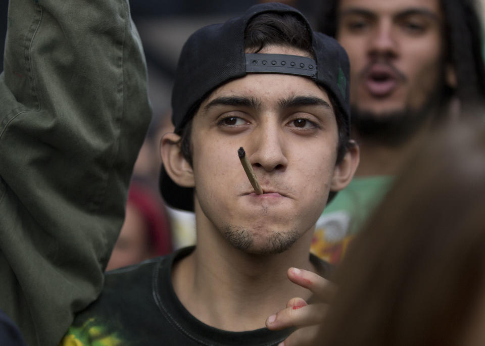 A demonstrator smokes a marijuana joint during a legalization of marijuana march in Sao Paulo, Brazil, Saturday, April 26, 2014. Brazilian police say about 2,000 people have gathered in downtown Sao Paulo in a demonstration demanding the legalization of the production and sale of marijuana in Latin America's largest country. (AP Photo/Andre Penner)