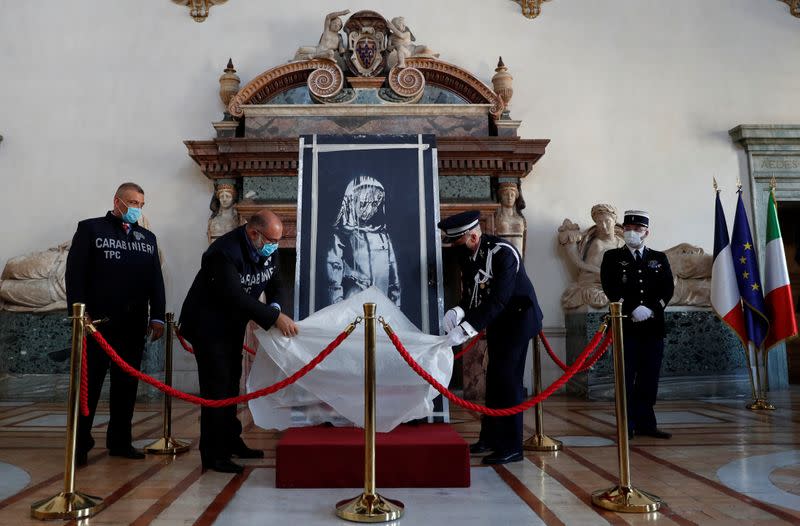 Foto del martes de la ceremonia de entrega a las autoridades de Francia de una puerta del teatro Bataclan con un mural pintado por Banksy recuperada en Italia tras su robo