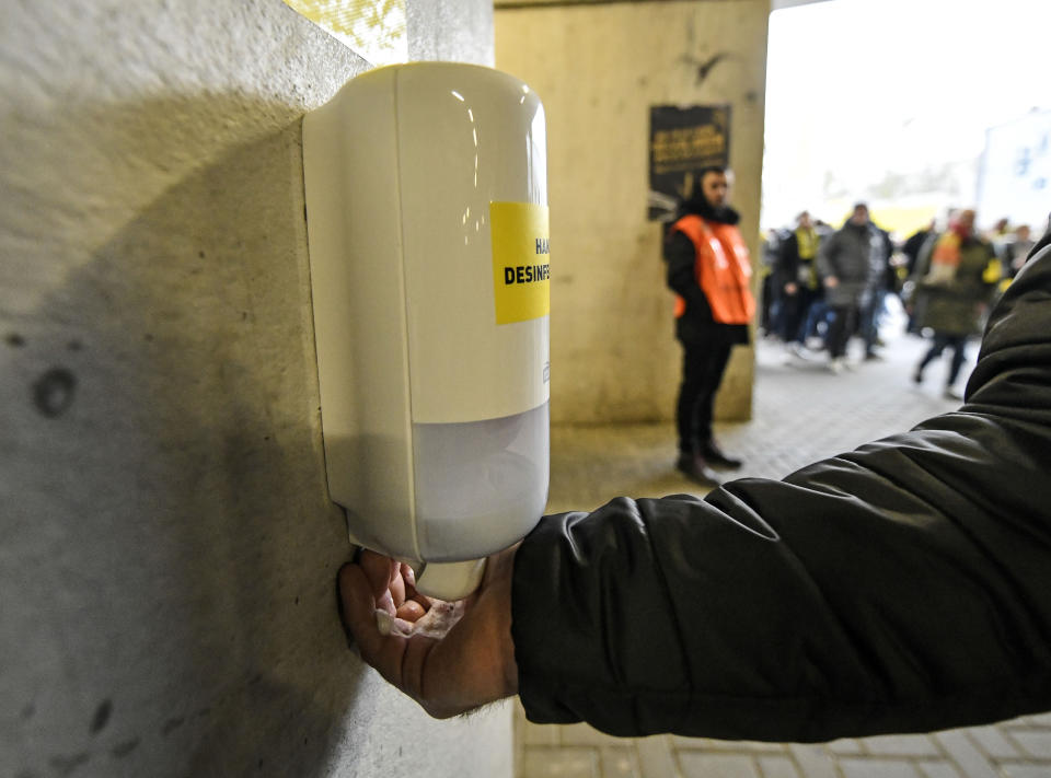 ARCHIVO - En esta foto del 29 de febrero de 2020, un aficionado se lava las manos en una nueva zona de desinfección durante un partido de la Bundesliga entre Borussia Dortmund y Freiburgo en Dortmund, Alemania. (AP Foto/Martin Meissner, archivo)