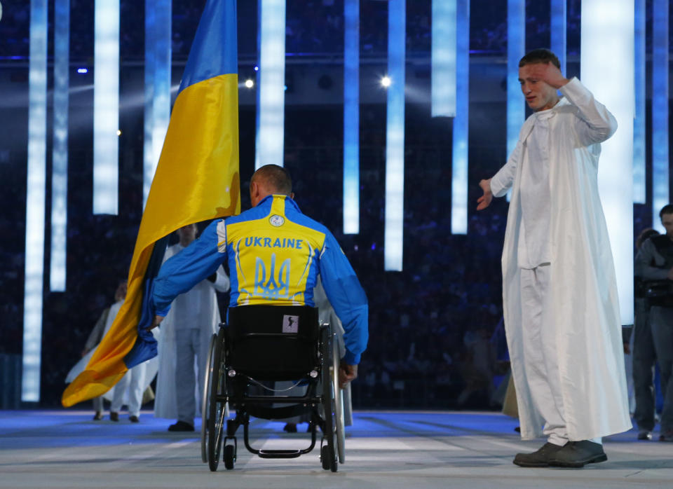 Biathlete Mykhaylo Tkachenko, representing Ukraine, enters the arena during the opening ceremony of the 2014 Winter Paralympics at the Fisht Olympic stadium in Sochi, Russia, Friday, March 7, 2014. (AP Photo/Dmitry Lovetsky)